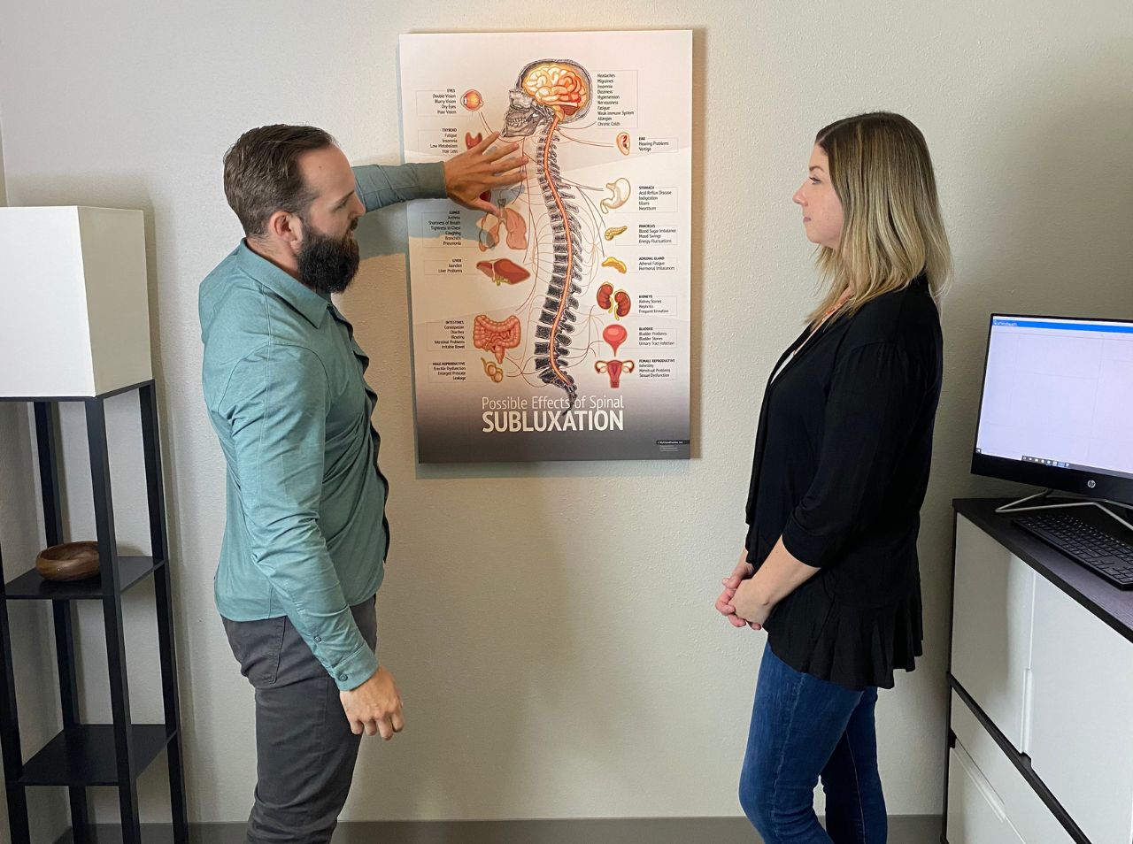 Dr. Walton discussing spinal subluxation treatment with female patient