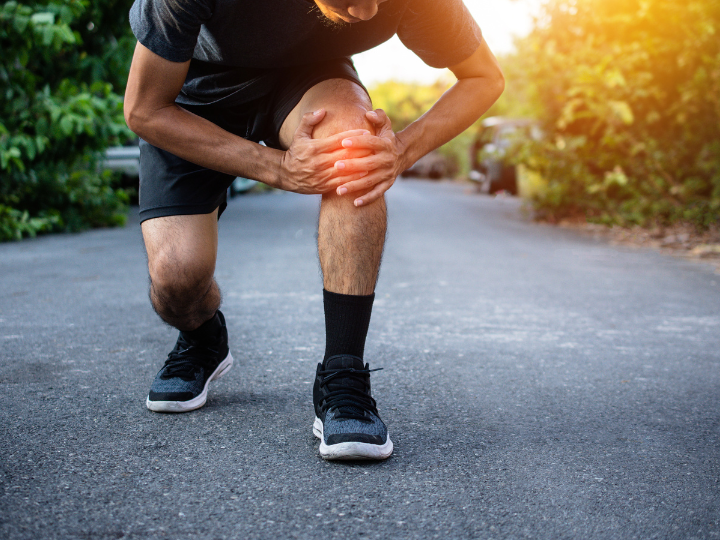 man suffering from knee pain during a jog